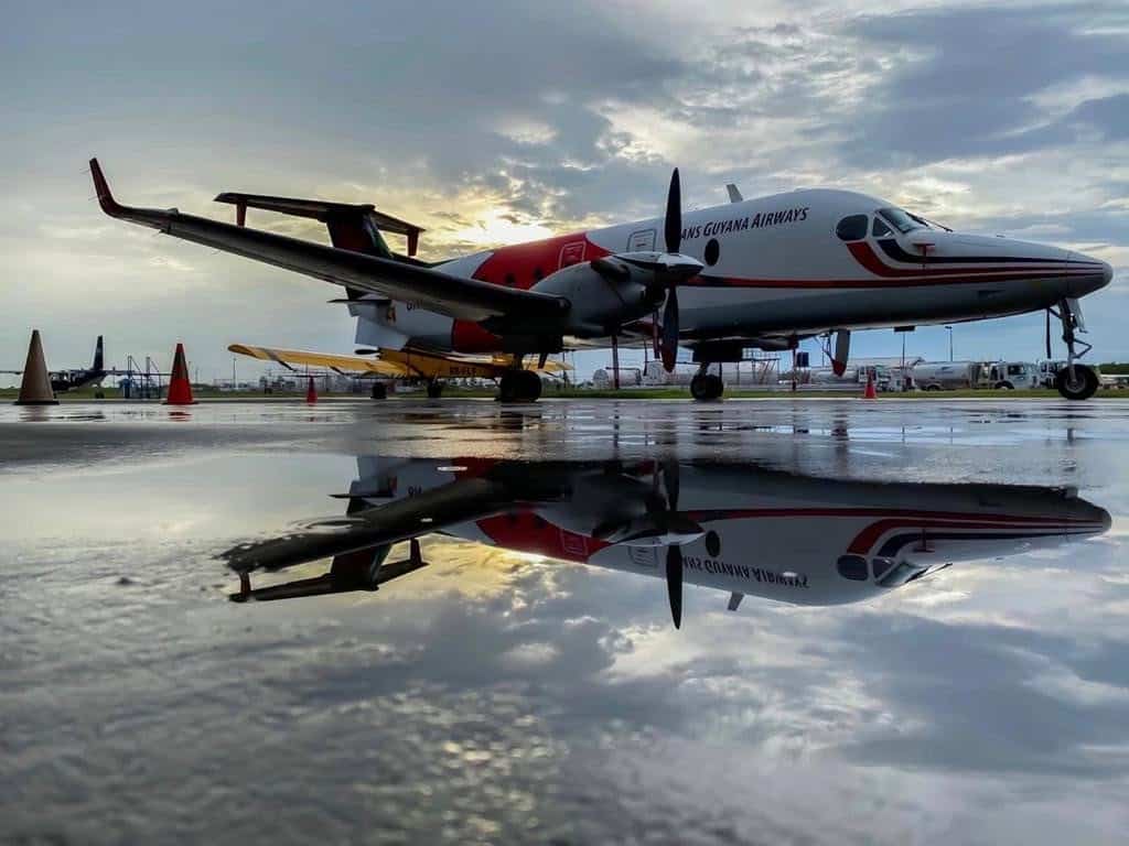 Avion de Trans Guyana Airways et son reflet sur la piste mouillée