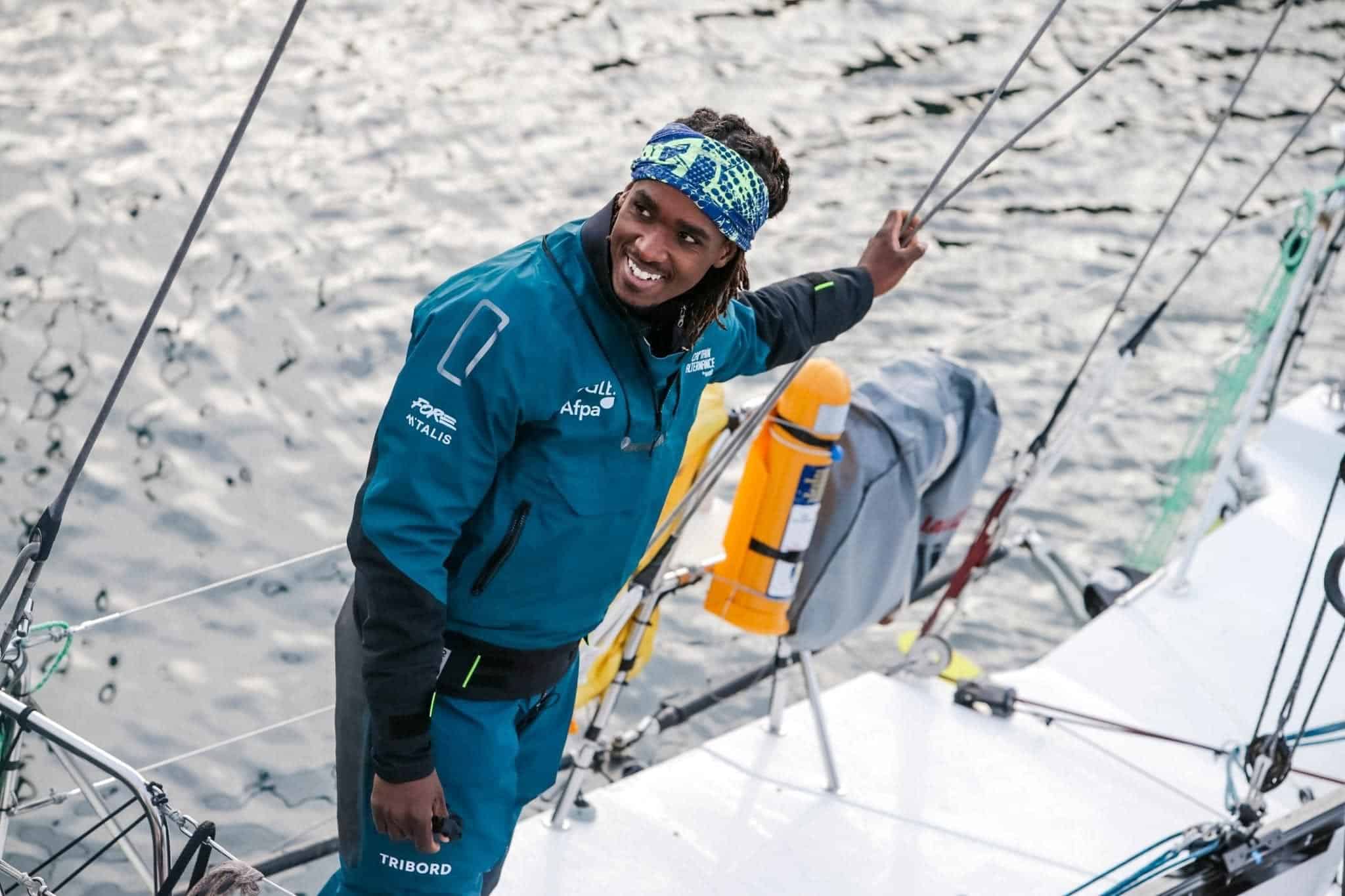 Kéni Piperol smiling on the deck of his sailboat, in sailing gear